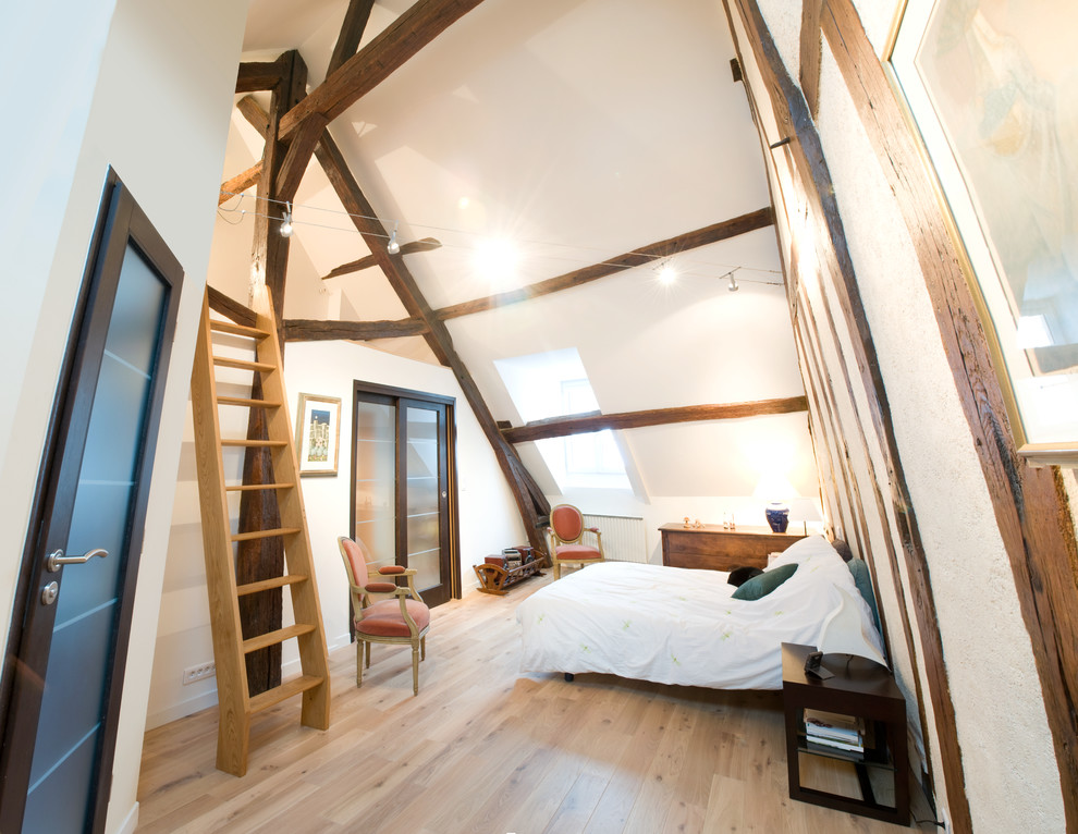 Ejemplo de dormitorio tipo loft y blanco y madera rural grande con paredes blancas y suelo de madera clara