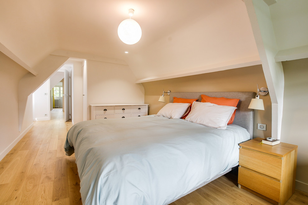 Cette photo montre une chambre d'amis éclectique de taille moyenne avec un mur blanc, parquet clair, aucune cheminée et un sol marron.