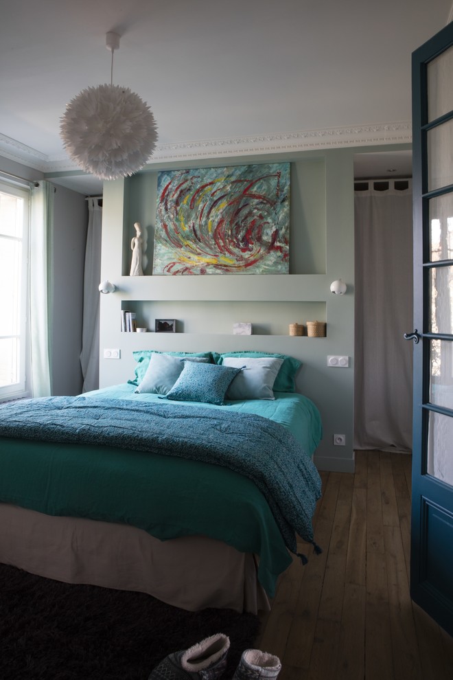 Modelo de dormitorio principal ecléctico de tamaño medio sin chimenea con paredes verdes, suelo de madera clara y suelo marrón