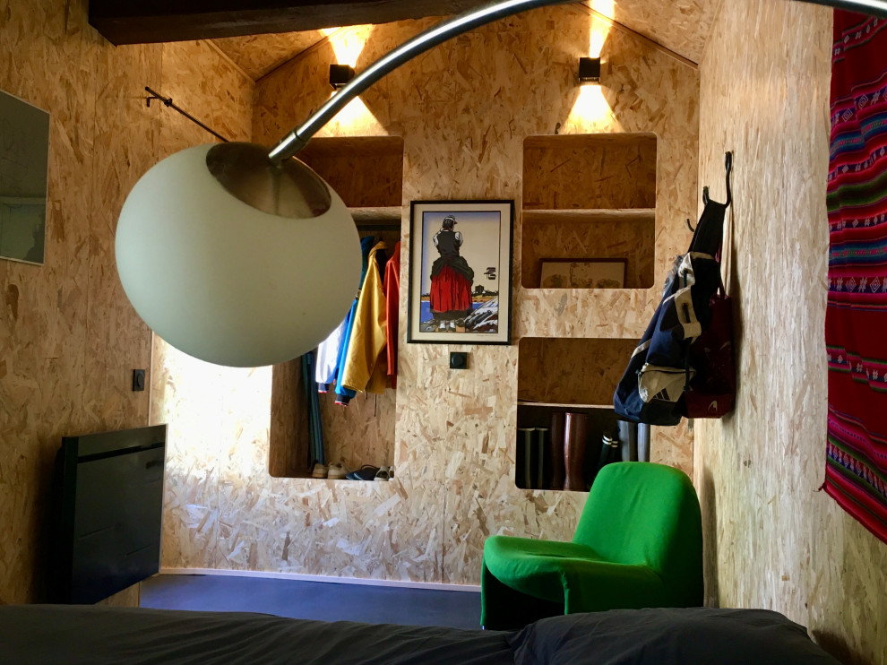 На фото: гостевая спальня среднего размера, (комната для гостей) в морском стиле с бетонным полом, черным полом, деревянным потолком и деревянными стенами