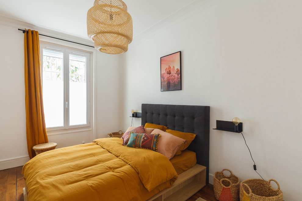 Idée de décoration pour une chambre parentale bohème de taille moyenne avec un mur blanc, parquet foncé et un sol marron.