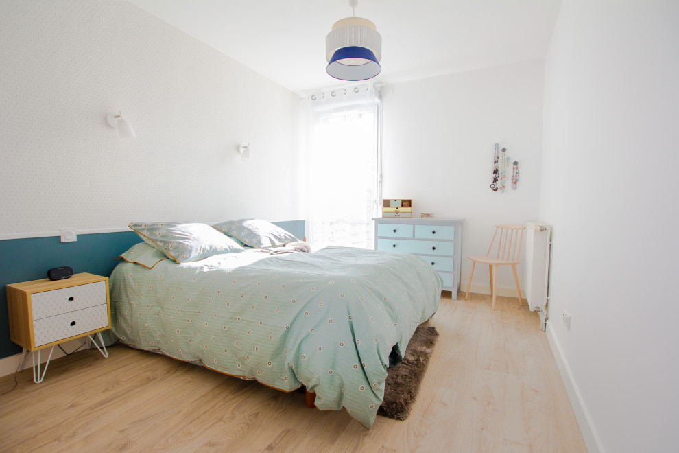Réalisation d'une chambre parentale design de taille moyenne avec un mur bleu, parquet clair et un sol marron.