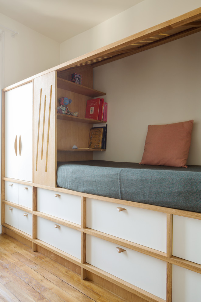 Diseño de dormitorio principal actual de tamaño medio con paredes blancas, suelo de madera clara y suelo beige