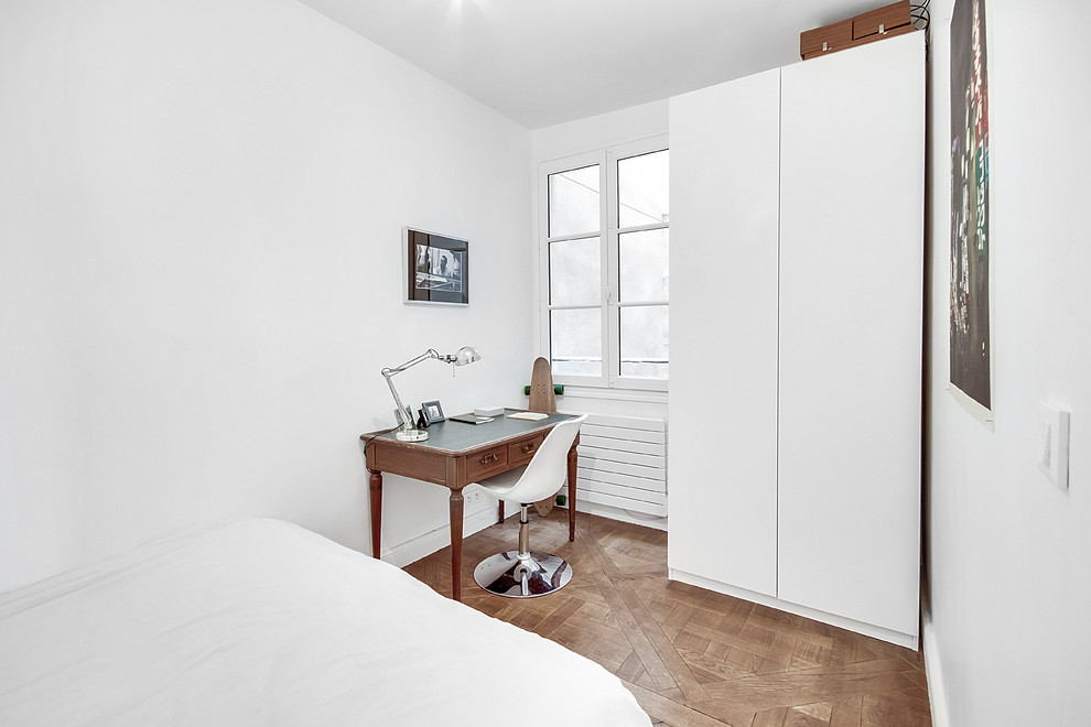 Ejemplo de dormitorio principal actual pequeño sin chimenea con paredes blancas, suelo de madera clara y suelo beige