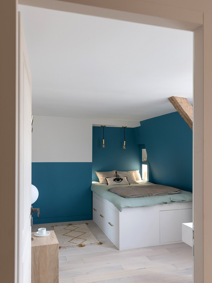 Cette photo montre une petite chambre tendance avec un mur bleu, parquet clair et un sol beige.