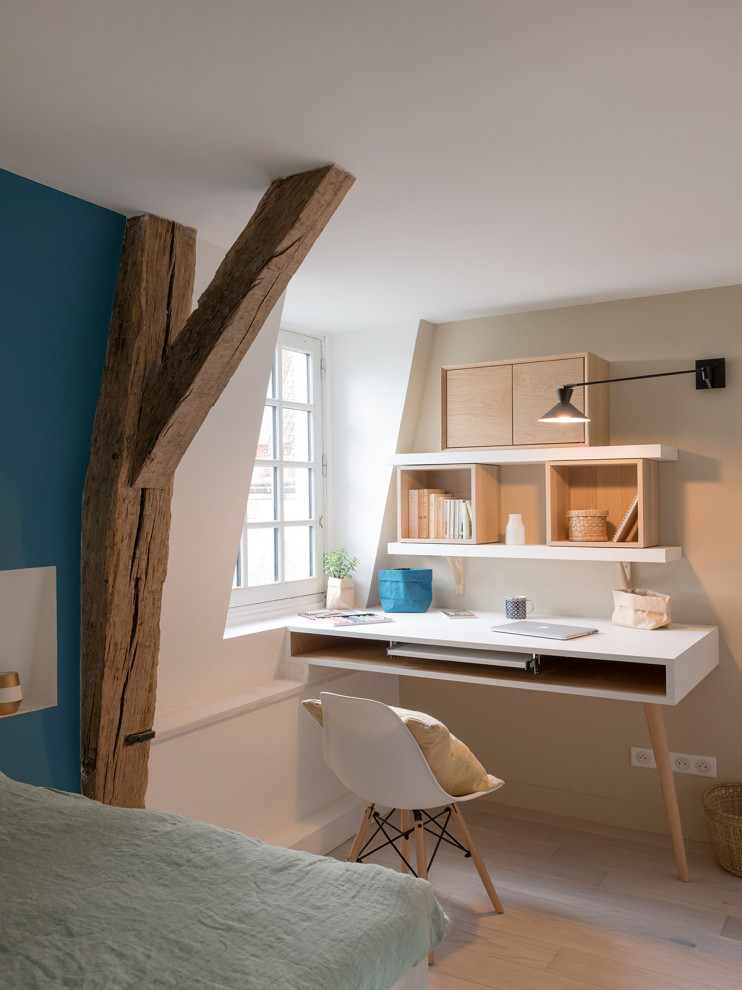 Modelo de dormitorio actual pequeño con paredes azules, suelo de madera clara y suelo beige
