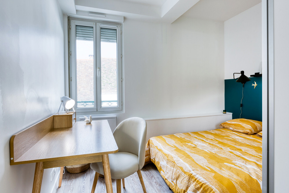 Idée de décoration pour une petite chambre parentale nordique avec un mur bleu, parquet clair et un sol gris.