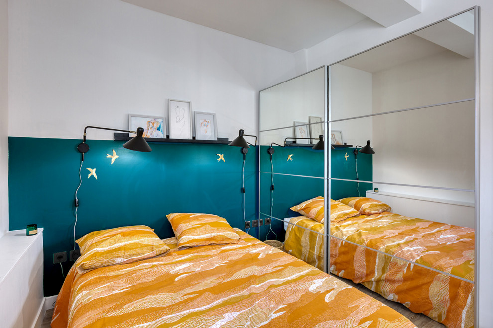 Ejemplo de dormitorio principal escandinavo pequeño con paredes azules, suelo de madera clara y suelo gris