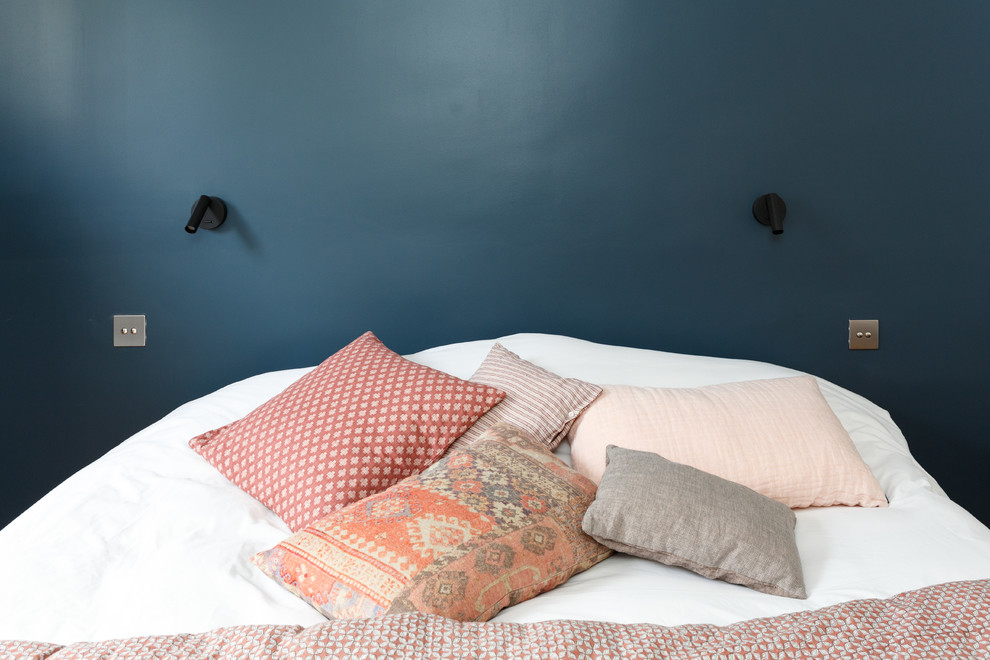 Imagen de dormitorio principal moderno de tamaño medio sin chimenea con paredes azules