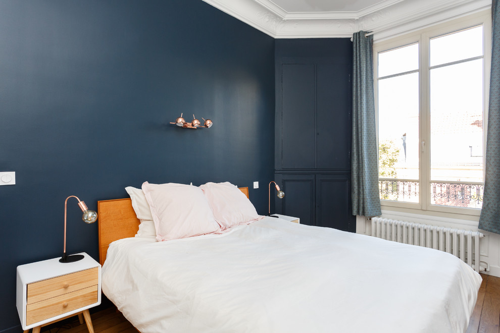 Idéer för ett mellanstort minimalistiskt huvudsovrum, med blå väggar, mellanmörkt trägolv, en standard öppen spis, en spiselkrans i sten och brunt golv