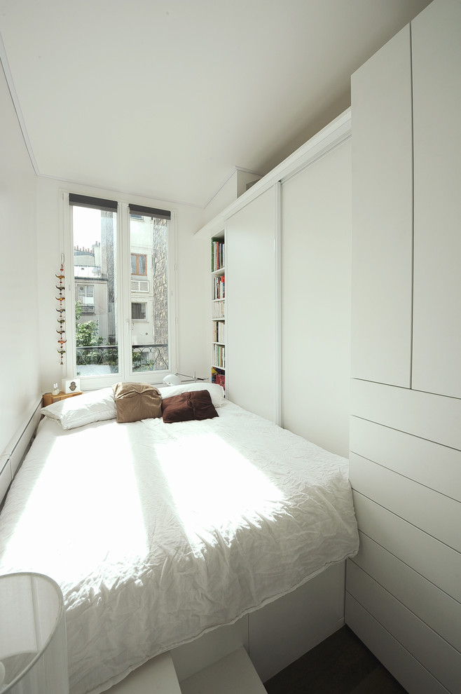 Inspiration pour une petite chambre parentale design avec un mur blanc, parquet foncé et un sol marron.