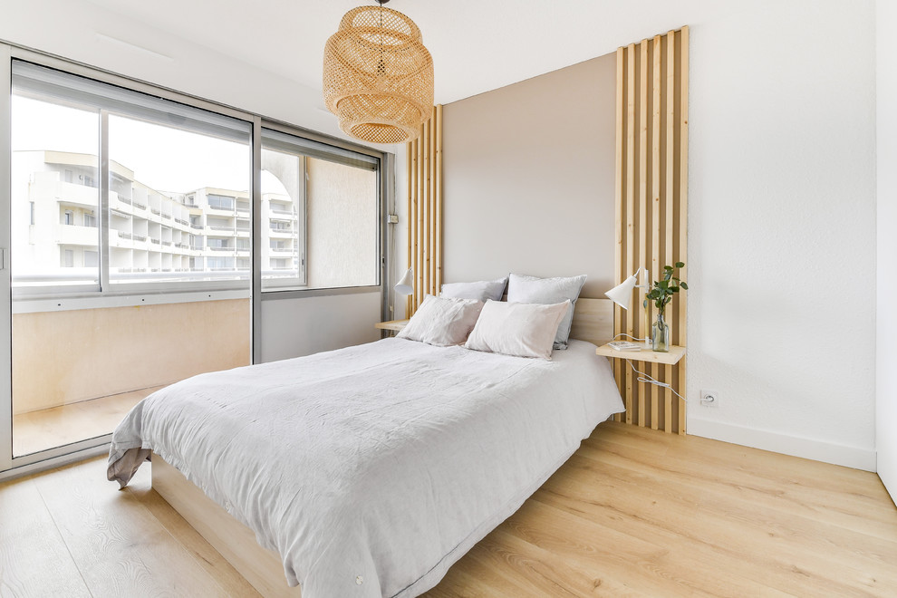 Ejemplo de dormitorio principal marinero de tamaño medio con paredes blancas, suelo laminado y suelo marrón