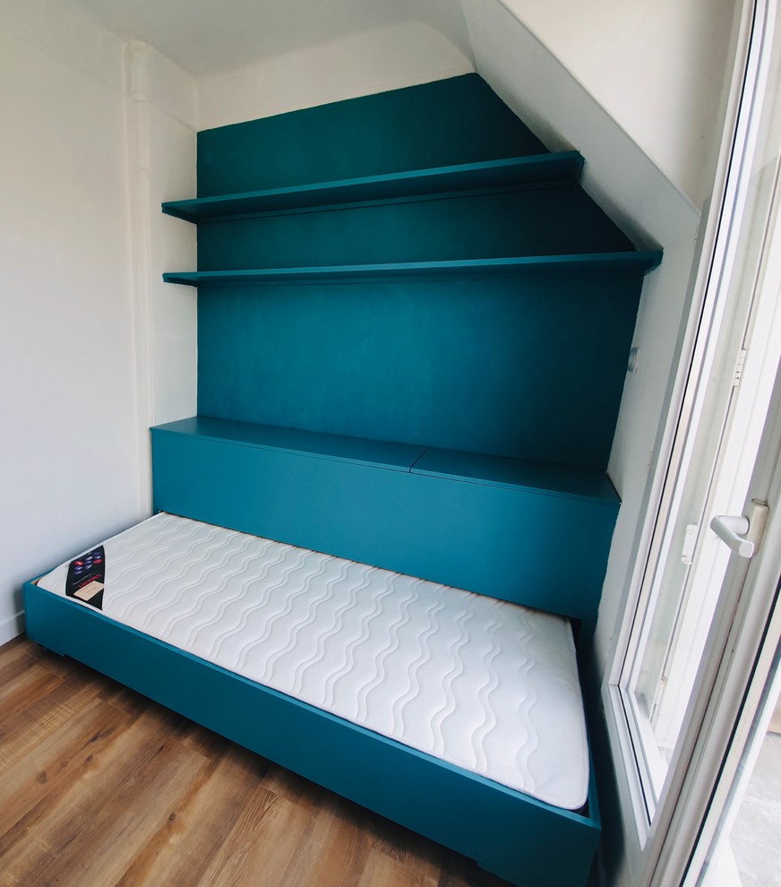 Diseño de dormitorio tipo loft contemporáneo pequeño con paredes azules y suelo laminado
