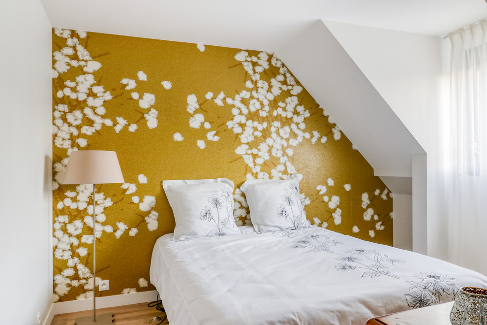 Foto de dormitorio principal moderno de tamaño medio con paredes amarillas, suelo de madera clara y suelo beige