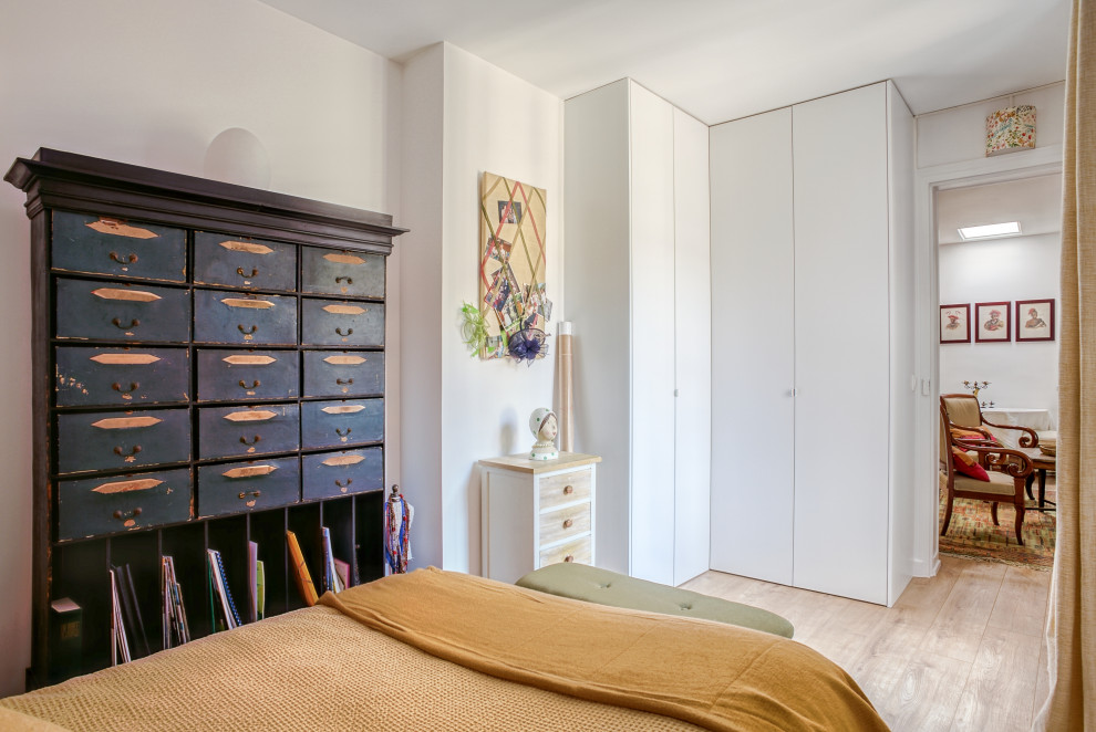 Ispirazione per una camera da letto boho chic di medie dimensioni con pareti bianche, parquet chiaro, camino classico e pavimento marrone