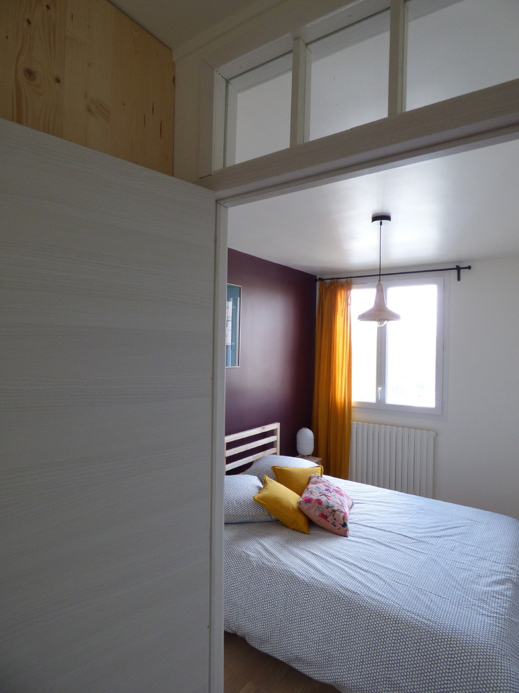 Idée de décoration pour une chambre parentale bohème de taille moyenne avec un mur violet, parquet clair et un sol marron.