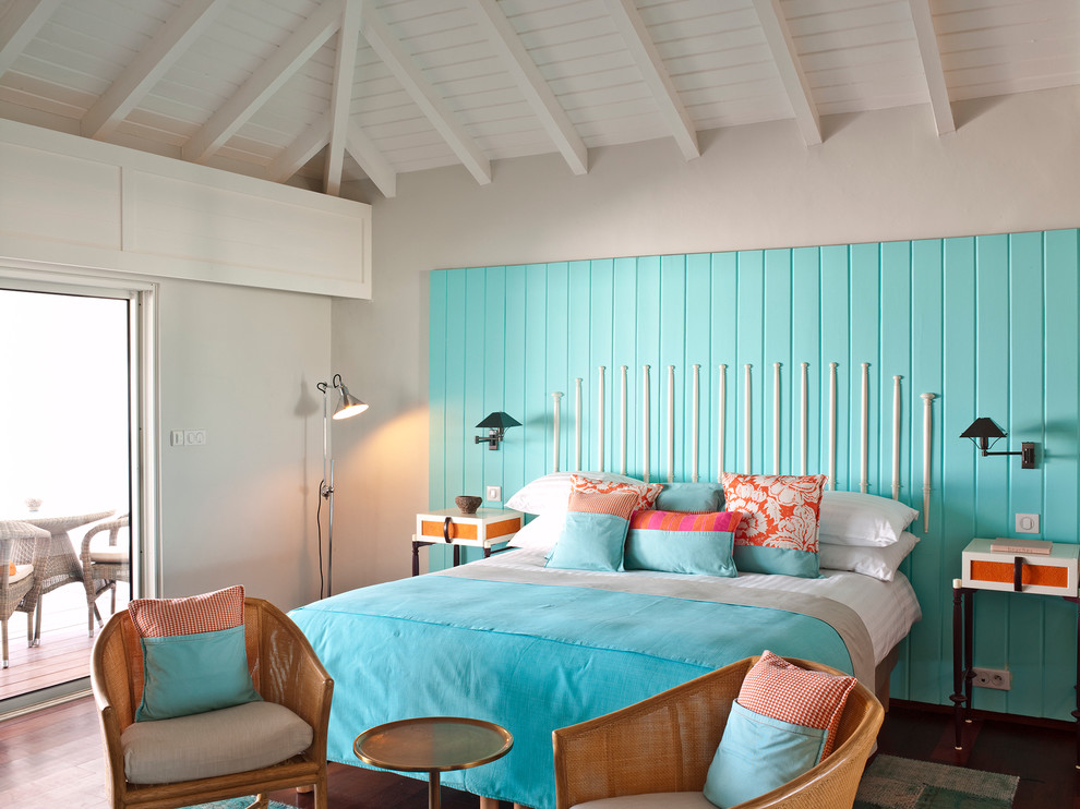 Imagen de dormitorio principal costero de tamaño medio sin chimenea con paredes grises y suelo de madera en tonos medios
