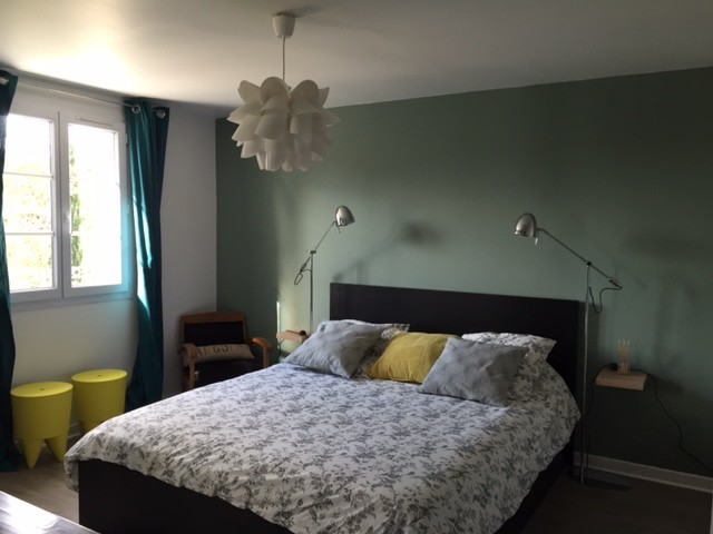 Foto de dormitorio principal contemporáneo pequeño con paredes verdes, suelo laminado y suelo marrón