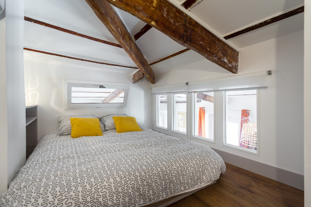 Imagen de dormitorio actual con paredes blancas y suelo de madera en tonos medios
