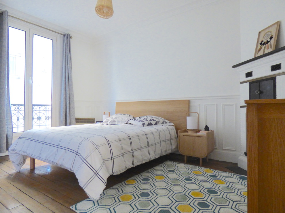 Aménagement d'une petite chambre parentale éclectique avec un mur blanc, parquet foncé, une cheminée standard, un manteau de cheminée en métal et un sol marron.