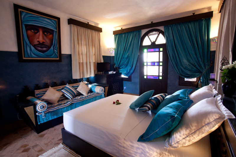 Пример оригинального дизайна: большая хозяйская спальня в средиземноморском стиле с синими стенами и полом из терракотовой плитки без камина