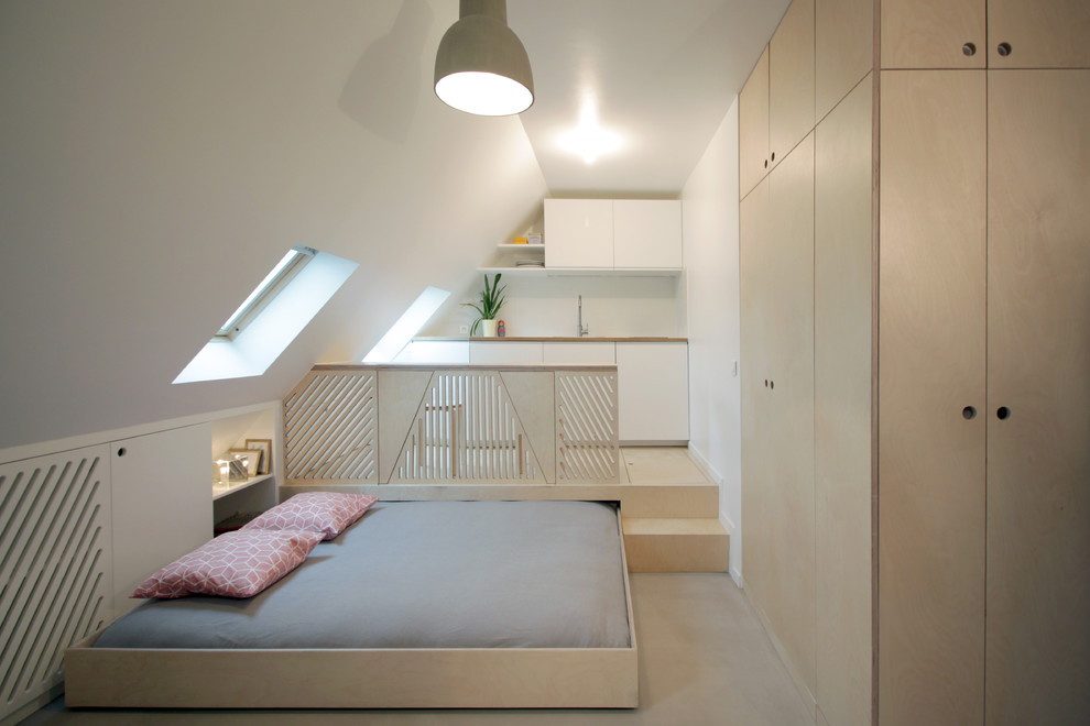 Kleines Modernes Gästezimmer ohne Kamin mit weißer Wandfarbe und Betonboden in Paris