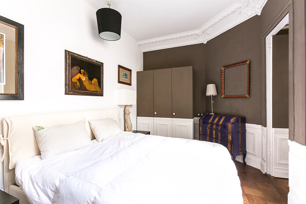 Aménagement d'une chambre parentale haussmannienne classique de taille moyenne avec un mur marron et un sol en bois brun.