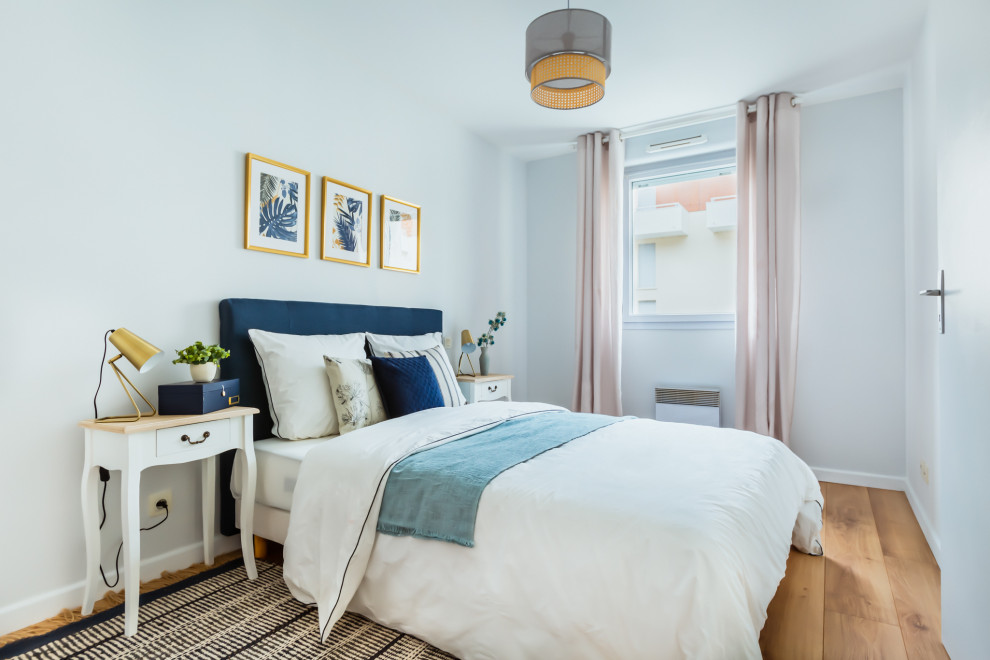Example of a mid-sized danish master light wood floor and brown floor bedroom design in Bordeaux with white walls