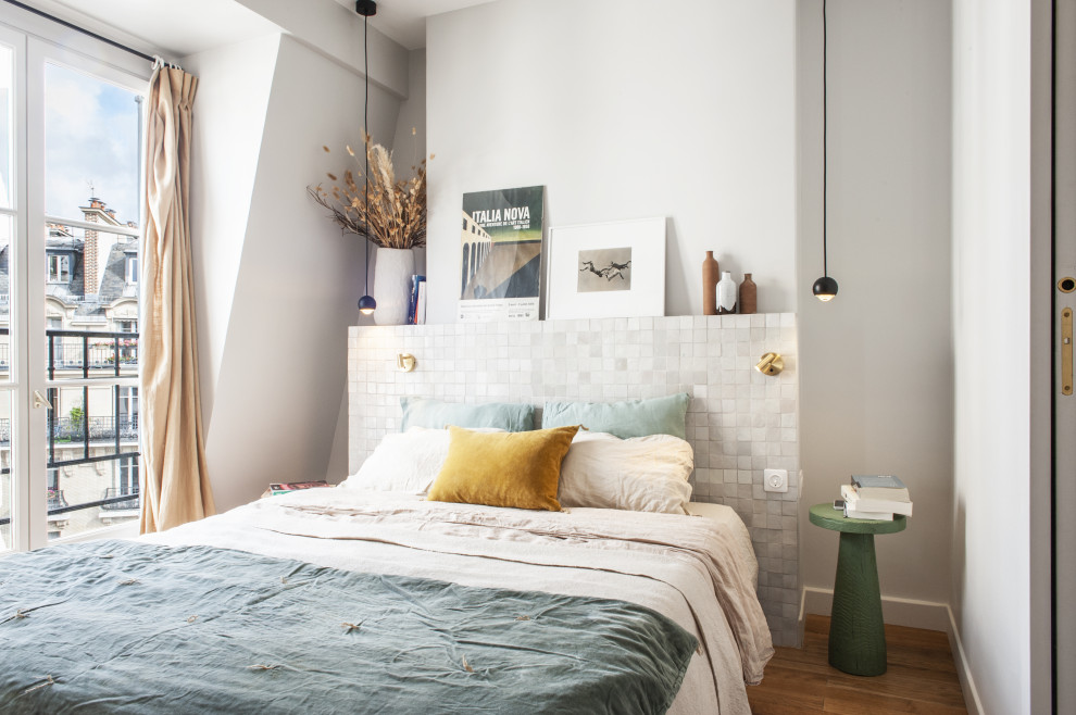 Immagine di una camera da letto eclettica con pareti bianche, pavimento in legno massello medio e pavimento marrone