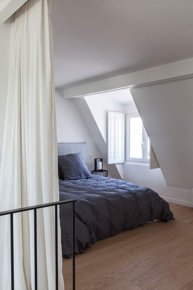 Mittelgroßes Modernes Schlafzimmer ohne Kamin, im Loft-Style mit weißer Wandfarbe, braunem Holzboden und braunem Boden in Paris