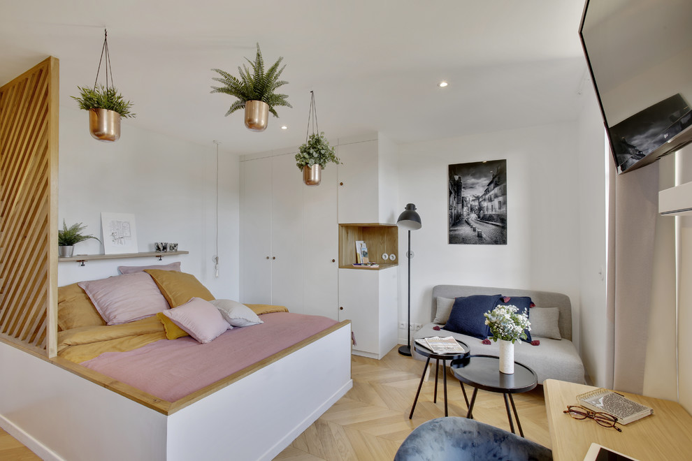 Photo of a small scandinavian master and grey and pink bedroom in Paris with white walls, light hardwood flooring and beige floors.