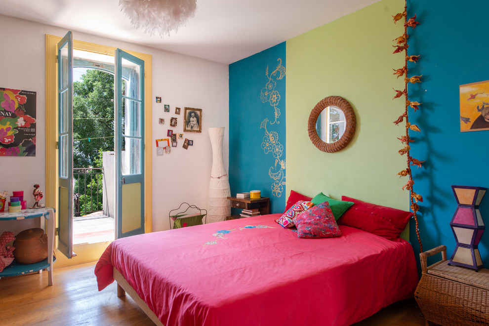 Diseño de dormitorio bohemio con paredes azules, suelo de madera en tonos medios y suelo marrón