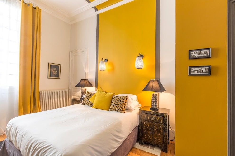 Aménagement d'une chambre haussmannienne et grise et jaune éclectique avec un mur jaune.