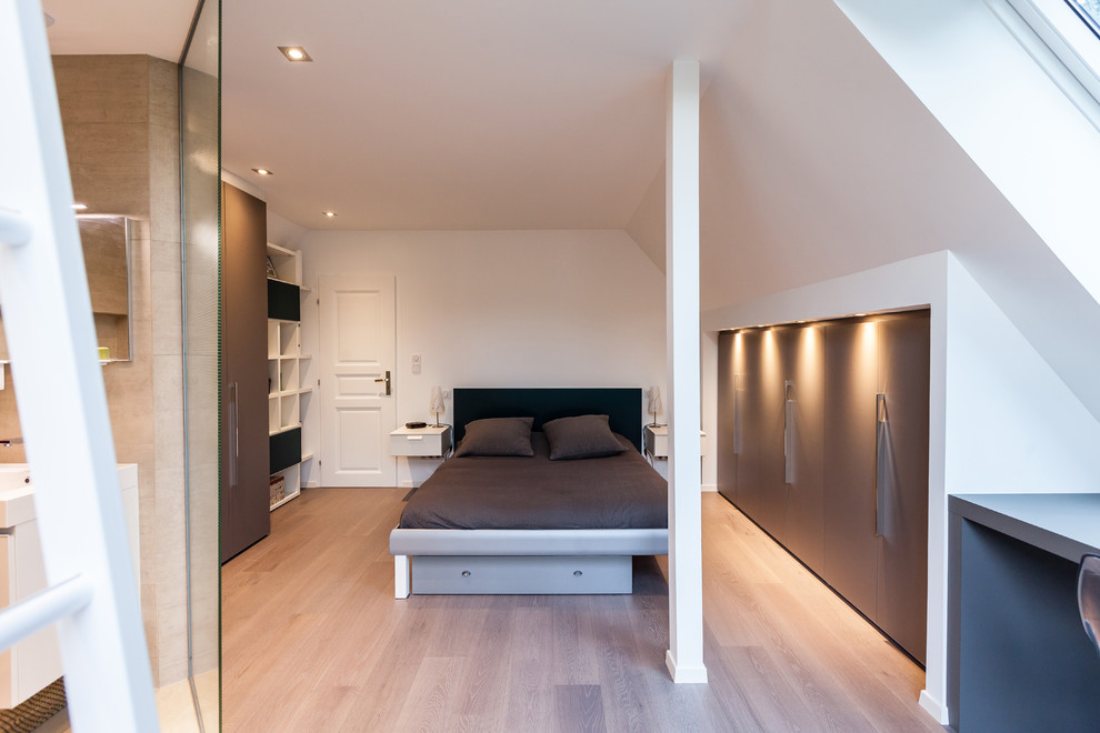 Example of a mid-sized trendy master light wood floor and beige floor bedroom design in Strasbourg with white walls
