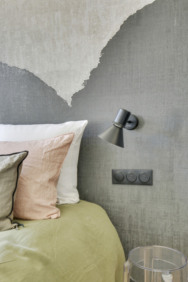 Ejemplo de dormitorio principal actual de tamaño medio con paredes beige, suelo de madera clara, suelo beige y papel pintado