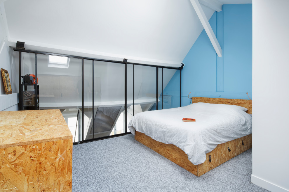 Foto på ett mellanstort industriellt sovloft, med blå väggar, heltäckningsmatta och grått golv