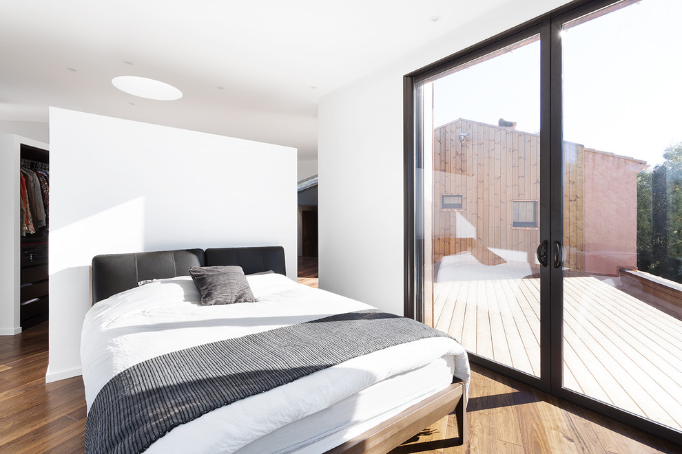 Mittelgroßes Modernes Hauptschlafzimmer ohne Kamin mit weißer Wandfarbe und braunem Holzboden in Montpellier