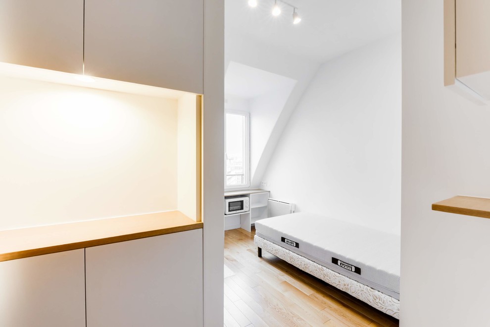 Idée de décoration pour une petite chambre design avec un mur blanc et parquet clair.