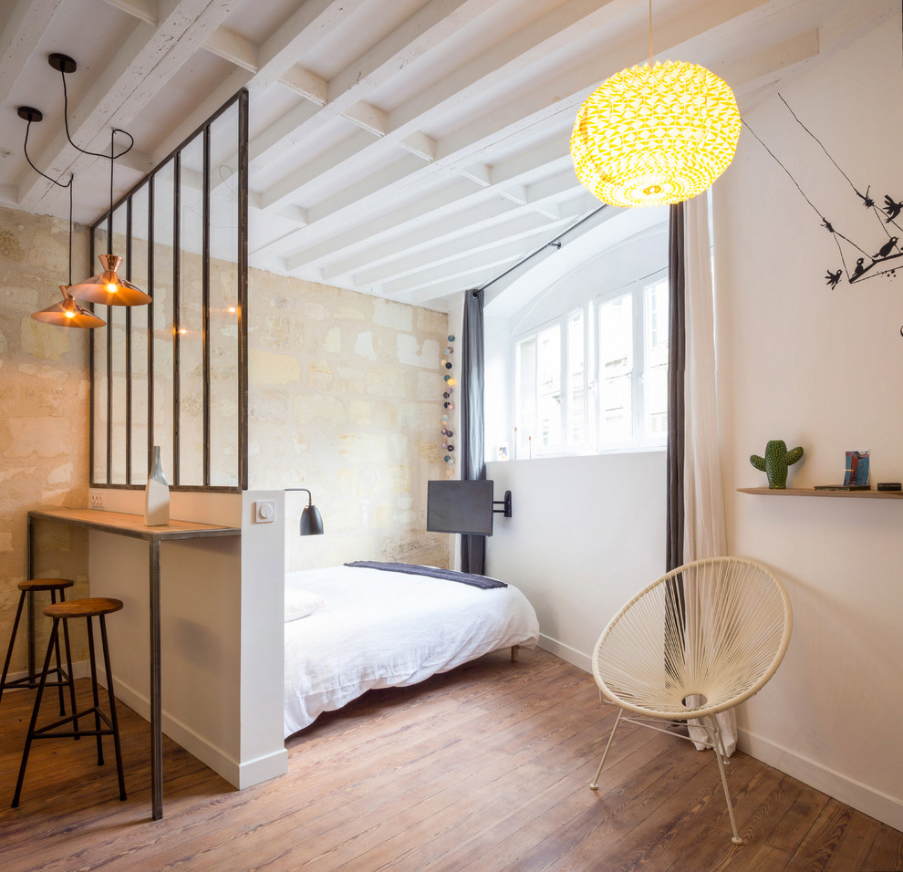 Aménagement d'une petite chambre contemporaine avec un mur blanc, un sol en bois brun et aucune cheminée.