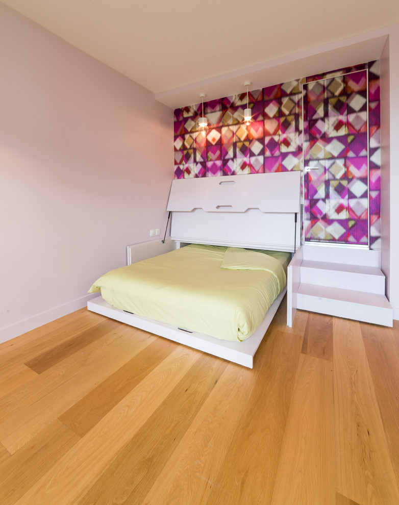 Immagine di una piccola camera matrimoniale design con pareti rosa, parquet chiaro, nessun camino e pavimento marrone