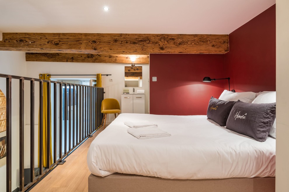 Idées déco pour une chambre mansardée ou avec mezzanine contemporaine avec un mur rouge, parquet clair et un sol beige.