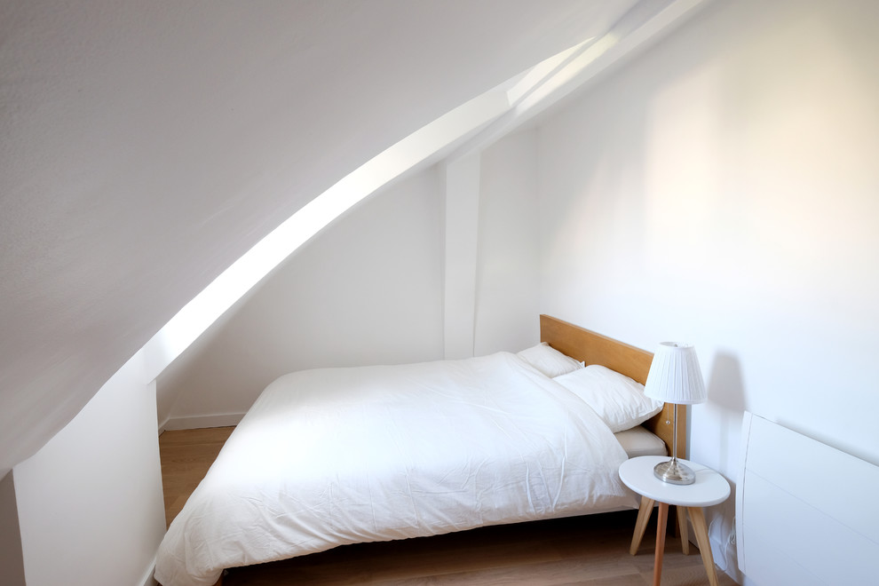 Ejemplo de dormitorio tipo loft nórdico pequeño con paredes blancas y suelo de madera clara