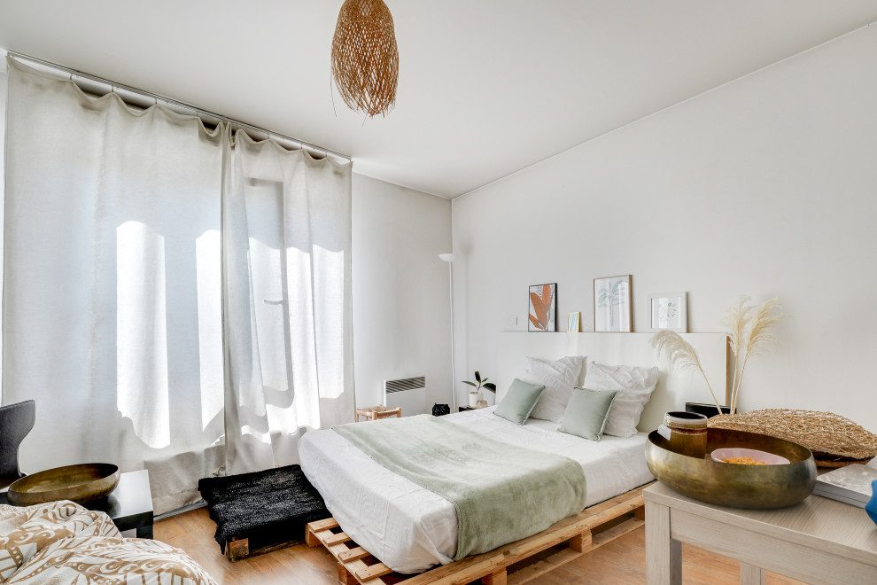 パリにあるトロピカルスタイルのおしゃれな寝室 (白い壁、無垢フローリング、茶色い床) のインテリア