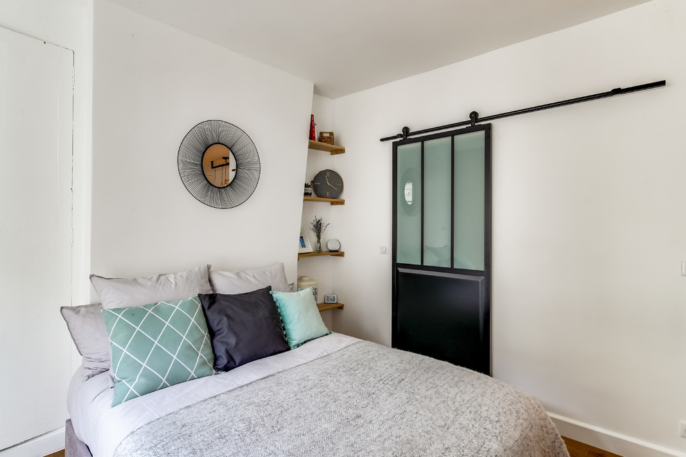 Kleines Retro Hauptschlafzimmer ohne Kamin mit weißer Wandfarbe, dunklem Holzboden und braunem Boden in Paris