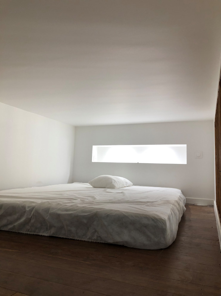 Small contemporary mezzanine bedroom in Marseille with white walls, bamboo flooring and brown floors.