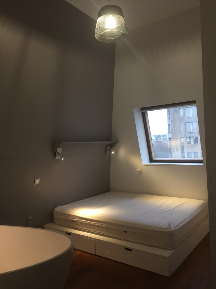 Modernes Schlafzimmer mit weißer Wandfarbe und dunklem Holzboden in Paris