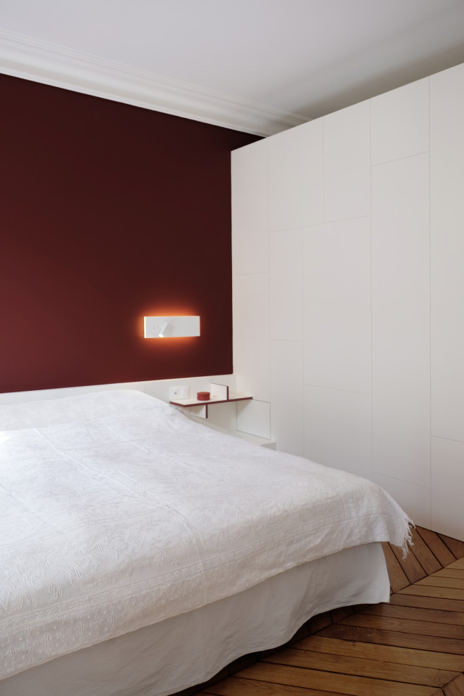 На фото: хозяйская спальня среднего размера в современном стиле с красными стенами и светлым паркетным полом