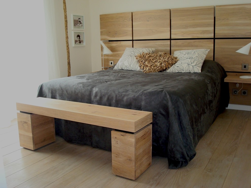 Example of a mid-sized trendy master light wood floor bedroom design in Paris with white walls