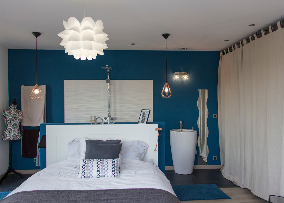 Großes Modernes Hauptschlafzimmer ohne Kamin mit blauer Wandfarbe und Laminat in Bordeaux