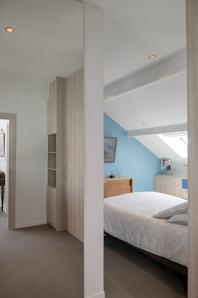 Exemple d'une chambre parentale tendance de taille moyenne avec un mur bleu, sol en béton ciré et un sol gris.
